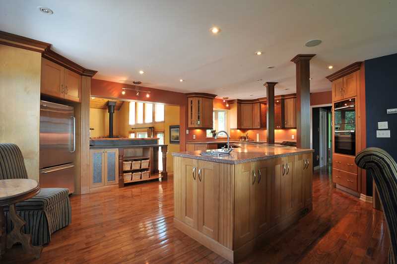 Maple Kitchen, w/ hardwood flooring, Corian counters, pot lights, huge centre island with bar sink, cook top and microwave